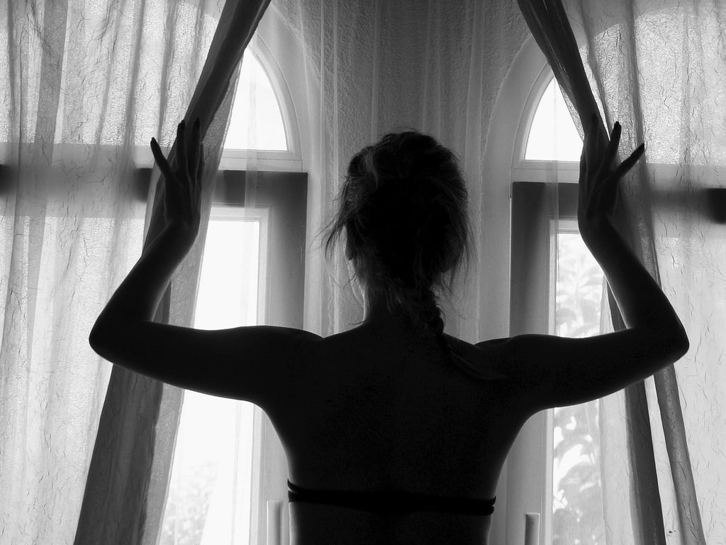 Silhouette of Woman Looking by the Window